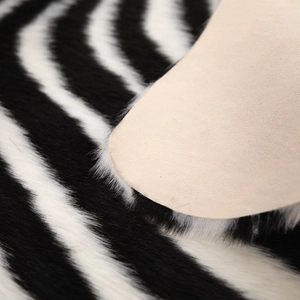 Detailopname van de zachte zebra imitatiebont textuur en beige suède achterkant