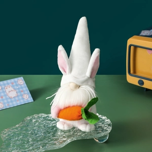 Easter gnome plush doll with rabbit ears holding a carrot on a decorative stand