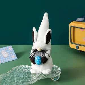 Easter bunny gnome plush decoration with blue polka dot egg on a green background