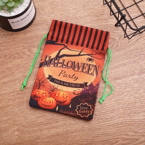 Halloween τσάντες γλυκών με κορδόνι και κολοκύθα σε ξύλινο τραπέζι με γιορτινά σχέδια