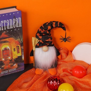 Halloween gnome plush with bat hat, spider charm and broom on orange background