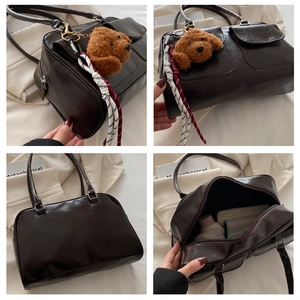 Detailansicht der kaffeebraunen PU-Leder Boston Bag mit Seitentaschen und Anhänger