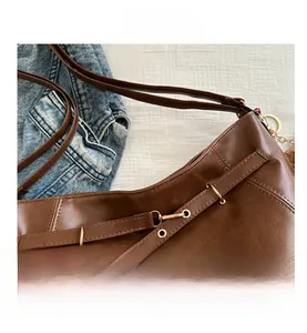Detail of vintage brown leather tote bag with fine stitching and gold metal ring eyelets