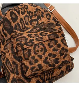 Detail of leopard print mini backpack fabric texture with silver buckle and brown straps