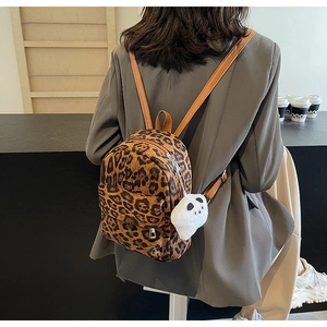Vue détaillée du mini sac à dos léopard avec fines bretelles et pendentif peluche