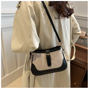 French retro canvas and black leather shoulder bag styled with a beige trench coat