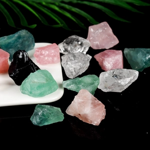 Natural raw crystal stones with pink quartz and green fluorite on a ceramic tray