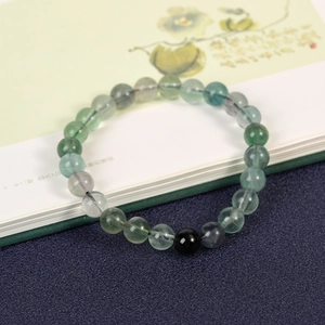 Natural green gemstone beaded bracelet with black onyx accent on vintage book pages