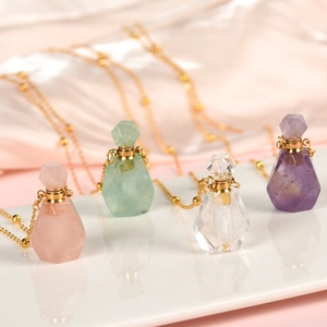 Quatre pendentifs flacons de parfum en cristal rose vert clair et violet sur chaîne dorée