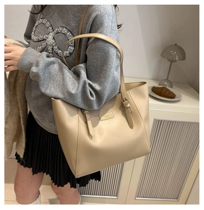 Large beige leather tote bag shown on model for daily commuting and student use