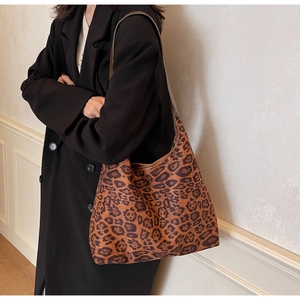 Dettaglio della borsa hobo leopardata indossata con un cappotto nero per il look autunno