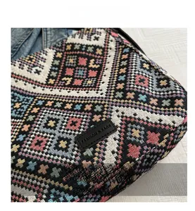 Detailed view of ethnic geometric jacquard fabric with woven cross patterns and leather patch