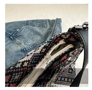Close-up of the smooth metal zipper and colorful ethnic woven fabric of the bucket bag