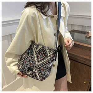 Close-up of ethnic geometric woven shoulder bag with vintage pattern and leather strap