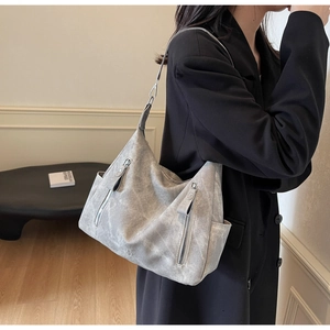Detail of grey vintage washed leather tote bag showing side pockets and vertical zippers