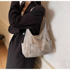 Close-up of vintage grey tote bag with dual front zippers and side pockets on a model