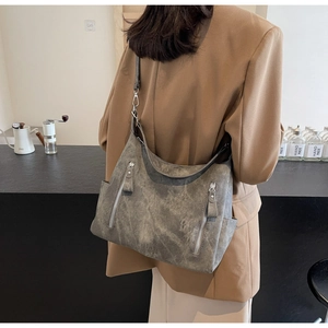 Close-up of vintage gray leather tote bag featuring side pockets and textured finish