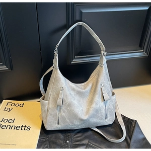 Detail of grey vintage tote bag showing vertical zippers and side pockets on matte leather