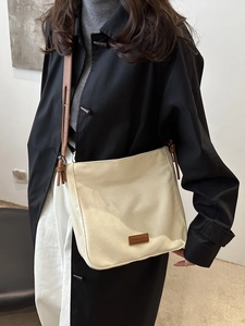Chic beige canvas bucket crossbody bag with brown leather straps for daily commute