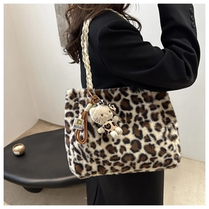 Detailed close-up of plush leopard print tote bag with woven rope handle and cat charm