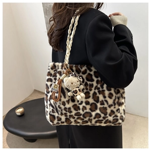 Detail of plush leopard print tote bag with braided handle and cute cat plush charm