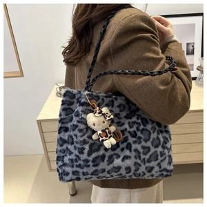 Close-up of blue leopard print plush tote bag with a soft faux fur texture and cat charm