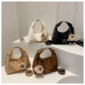 Detail view of crescent bags in four colors with sheep charms and metal handles