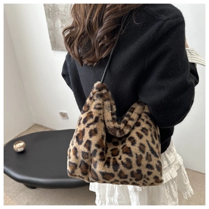 Rear view of a model wearing the large leopard print faux fur tote bag with black strap
