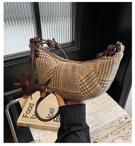 Detail der karierten Hobo-Tasche mit Lederriemen und braunem Dackel-Anhänger