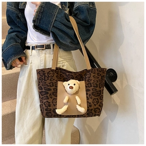 Détail du sac cabas léopard avec un ours en peluche 3D et des anses kaki