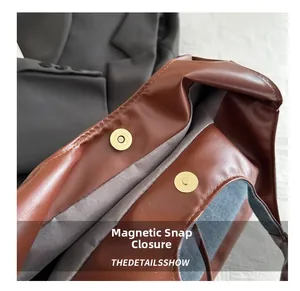 Vista macro della chiusura magnetica dorata su una borsa tote in pelle marrone
