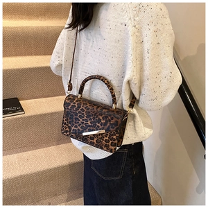 Close-up of leopard print handbag with gold hardware decoration and adjustable strap