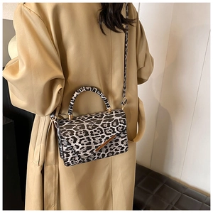 Detail of leopard print handbag with magnetic closure and gold-toned metal hardware trim