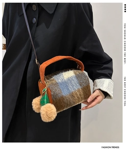 Détail du sac bandoulière pelucheux à carreaux avec pompons et sangle en velours