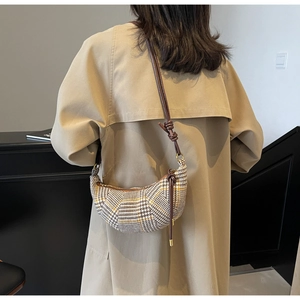 Detail der Vintage-Leoparden-Beuteltasche mit Lederriemen am beigen Trenchcoat