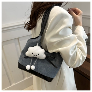 Détail du sac cabas en denim gris et cuir noir avec un charmant nuage en peluche