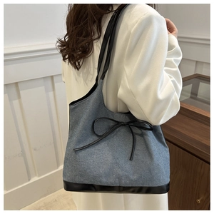 Détail du sac fourre-tout en denim vintage avec bordure en cuir et nœud chic