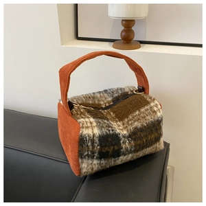 Détail d'un sac à main en laine à carreaux avec velours orange et zip métallique doré
