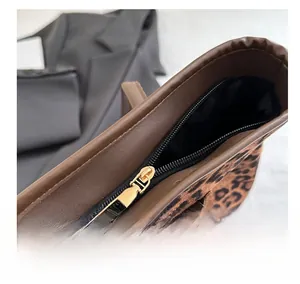 Macro detail of high-quality leopard print tote bag featuring a smooth gold zipper closure