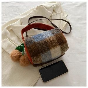 Détail du sac cylindre à carreaux avec poignée orange, breloque en peluche et échelle mobile