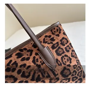 Macro detail of leopard print faux fur fabric with premium brown leather stitching