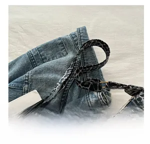 Close-up of leopard print canvas shoulder strap with adjustable golden metal buckle