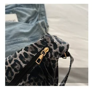 Close-up of a smooth gold metal zipper on a leopard print canvas tote bag details