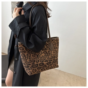 Model wearing a large leopard print tote bag showing the actual size and carrying style