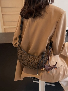 Leopard-Croissant-Tasche mit schwarzem Knotengurt und Hundeanhänger auf braunem Blazer