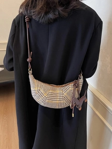 Braune Houndstooth-Sichelttasche mit Lederriemen und Welpenanhänger am Modell