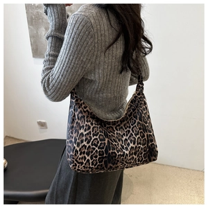 Detail of leopard print canvas tote bag on model showing large capacity and soft texture