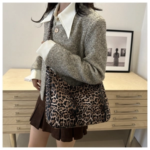 Detailed view of large leopard print canvas hobo bag styled with a grey tweed jacket
