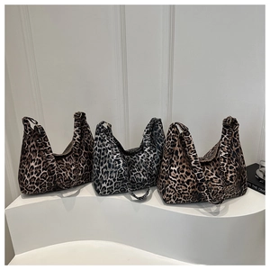 Detailed comparison of three leopard print canvas hobo bags on white pedestals
