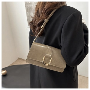Detail of retro khaki underarm bag with golden horseshoe buckle and textured leather